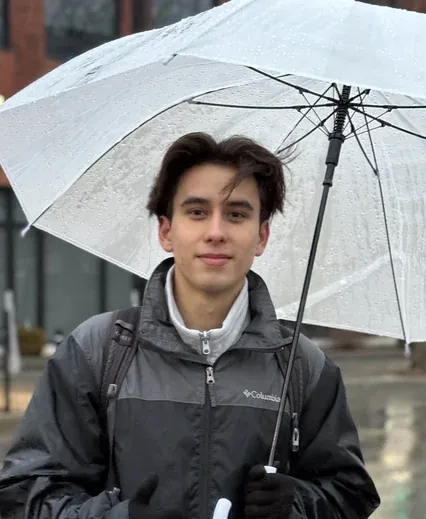 Antoine Oparin smiling under a clear umbrella